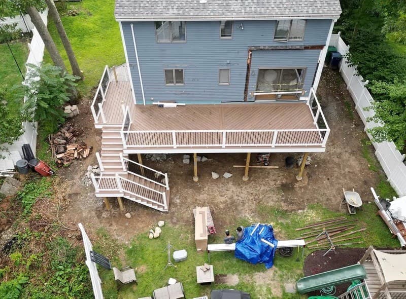 Finished elevated deck with white railings and stairs, from above