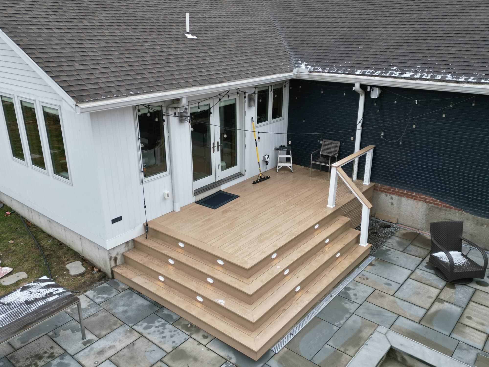 Composite deck with wraparound steps to a bluestone patio