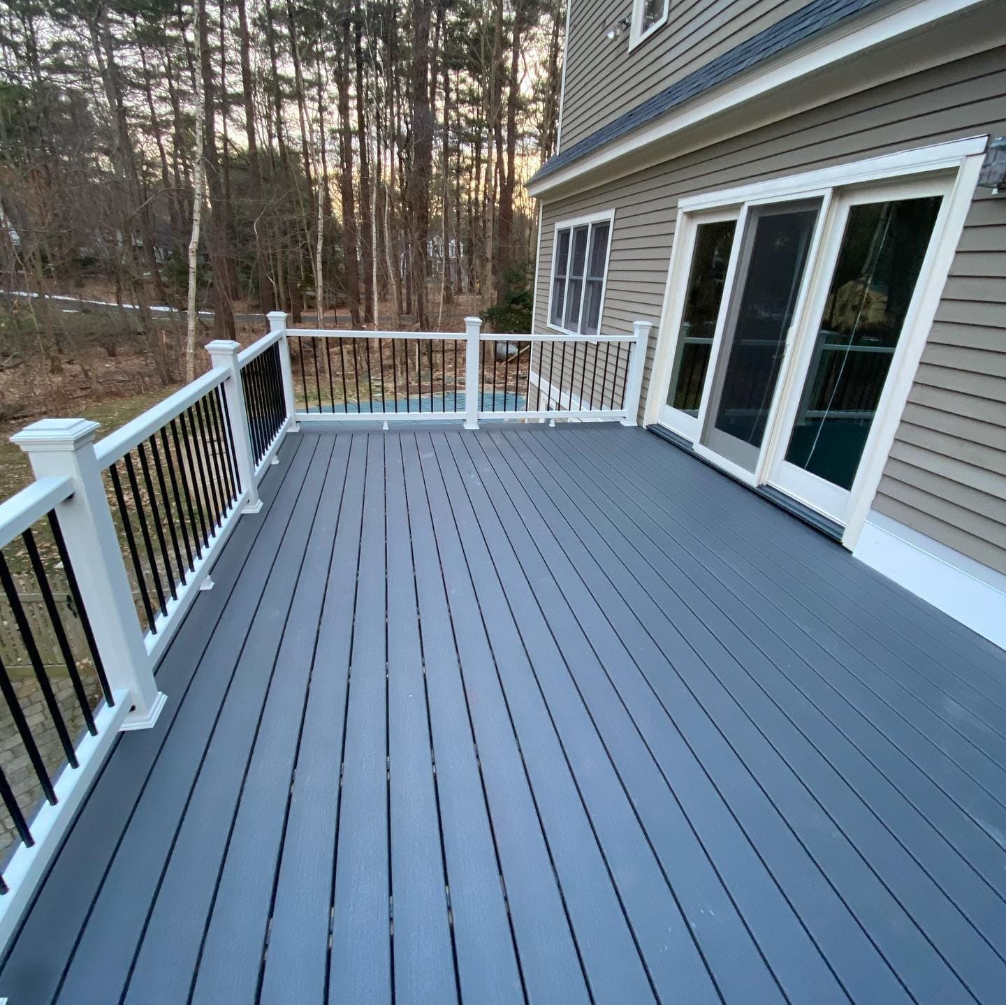 Grey composite deck with white railing and black balusters