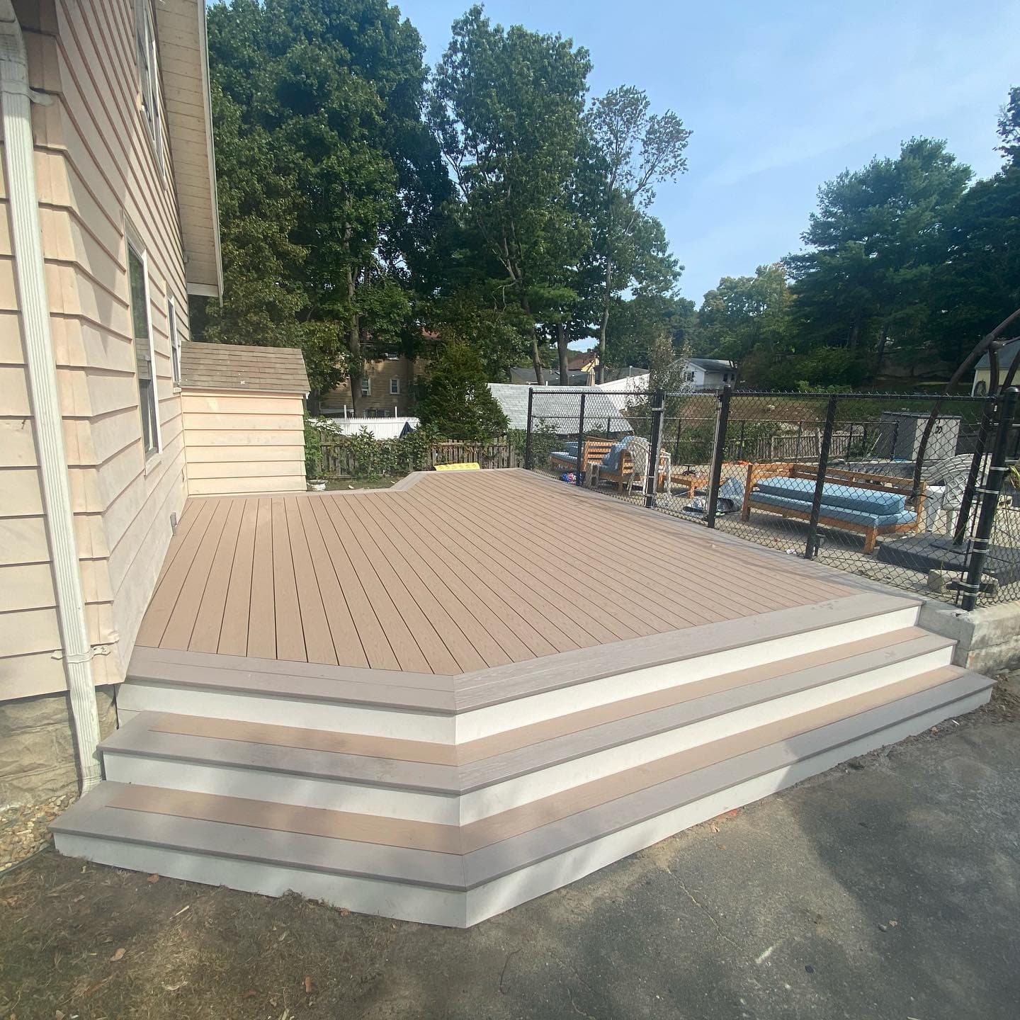 Low composite deck with wide steps down to the driveway