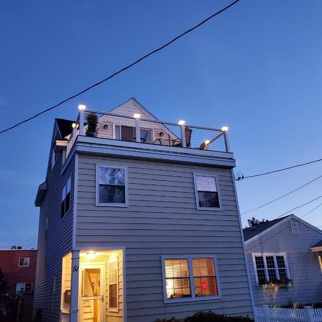 Rooftop deck with railing lights glowing at dusk