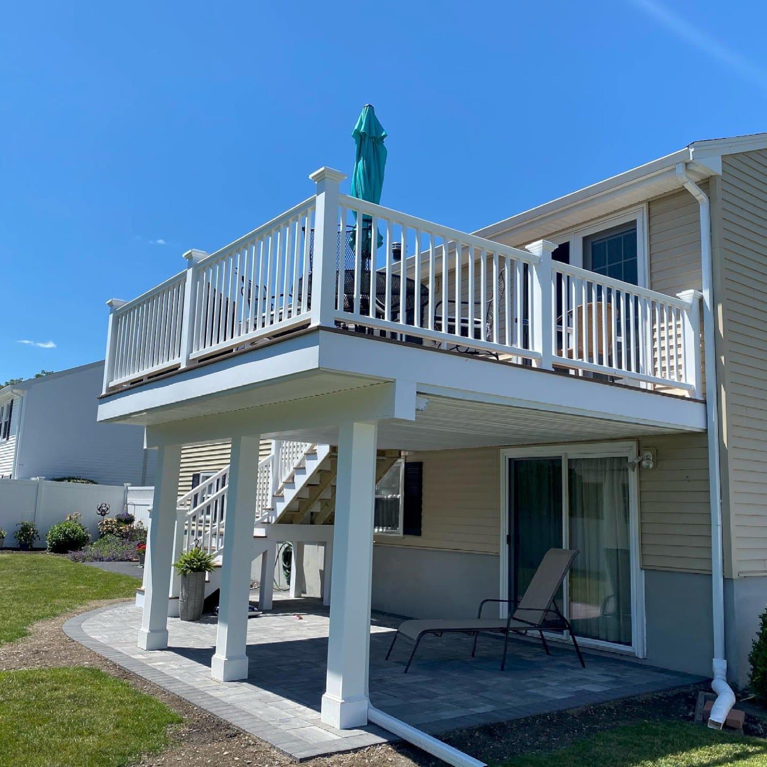 Second-story deck on white columns with a covered patio underneath