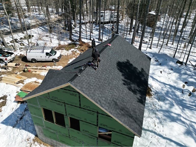 Addition framed and sheathed, roof shingled, during construction in winter