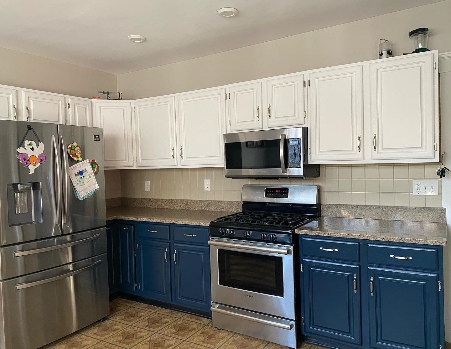 Refinished kitchen with white upper cabinets and navy lowers