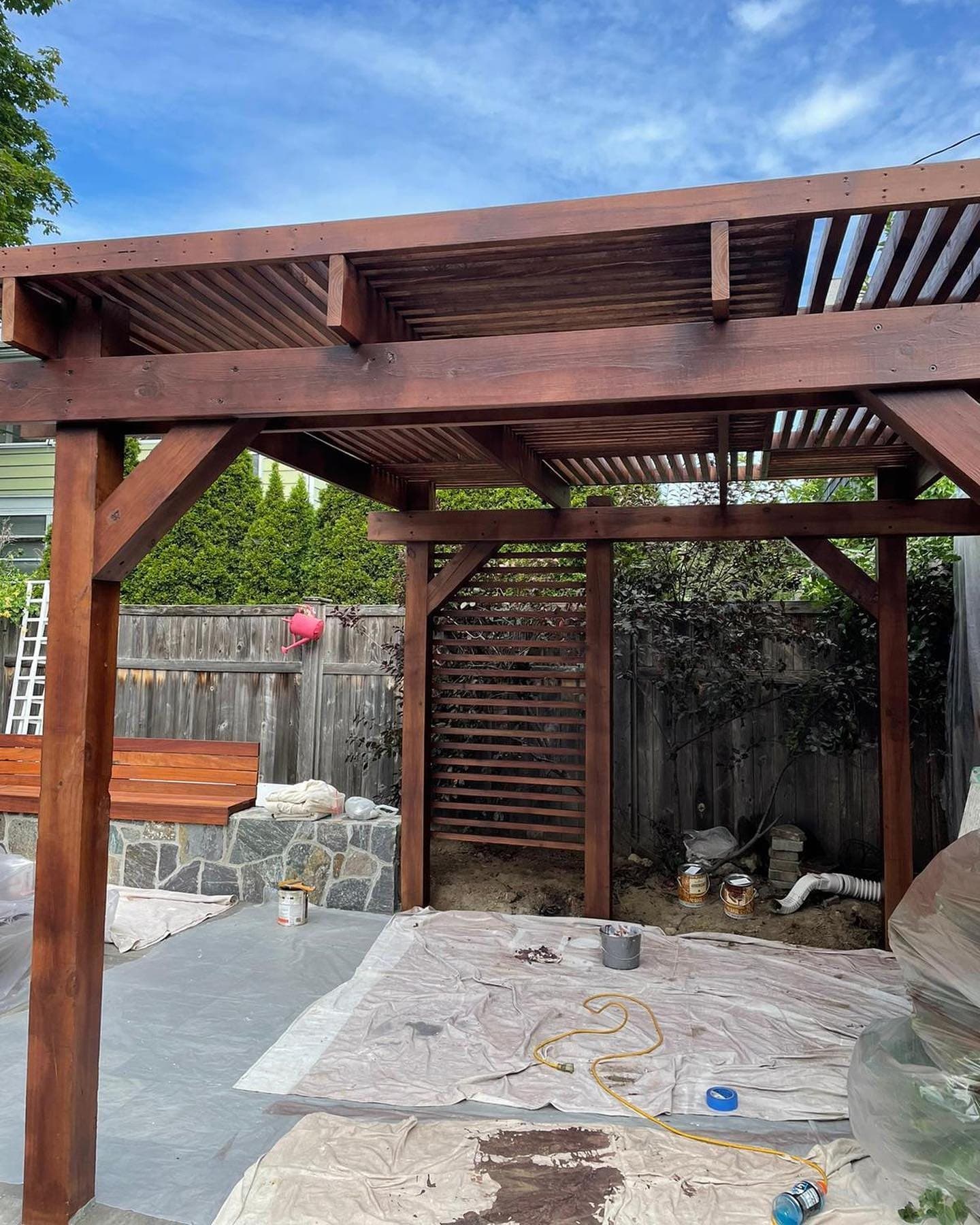 Custom stained pergola over a stone patio