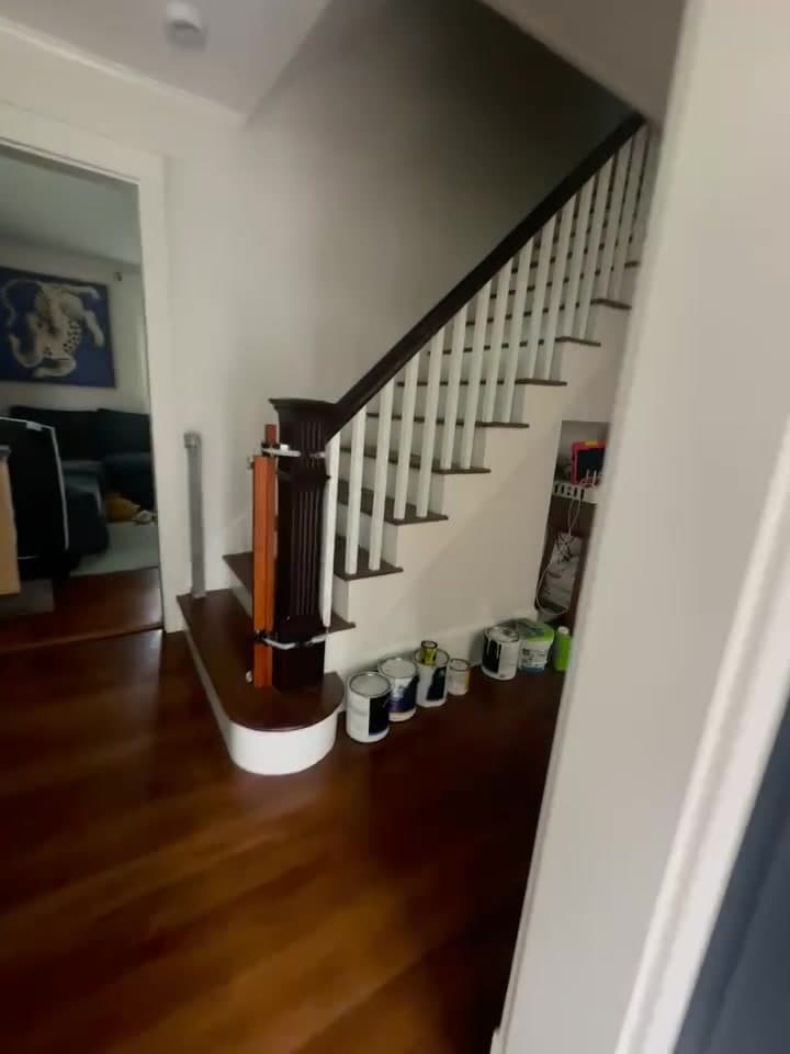 Renovated entry with a white stair rail and refinished hardwood
