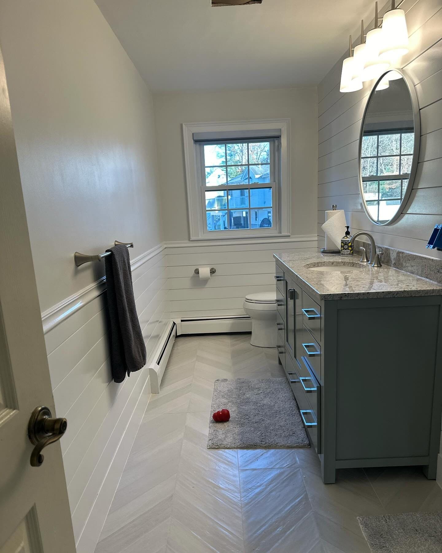 Grey vanity and herringbone floor
