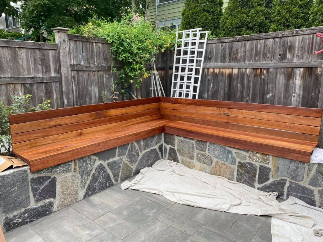 Custom wood bench built on top of a stone wall