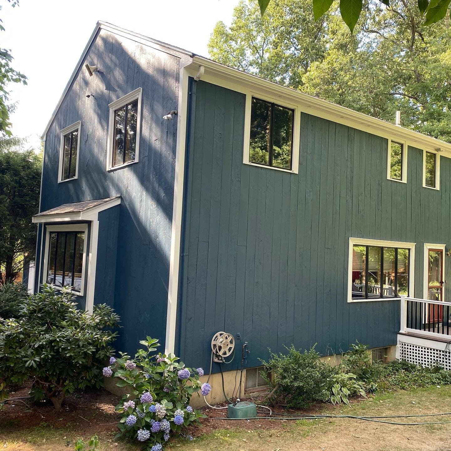 Home with green vertical siding and white trim