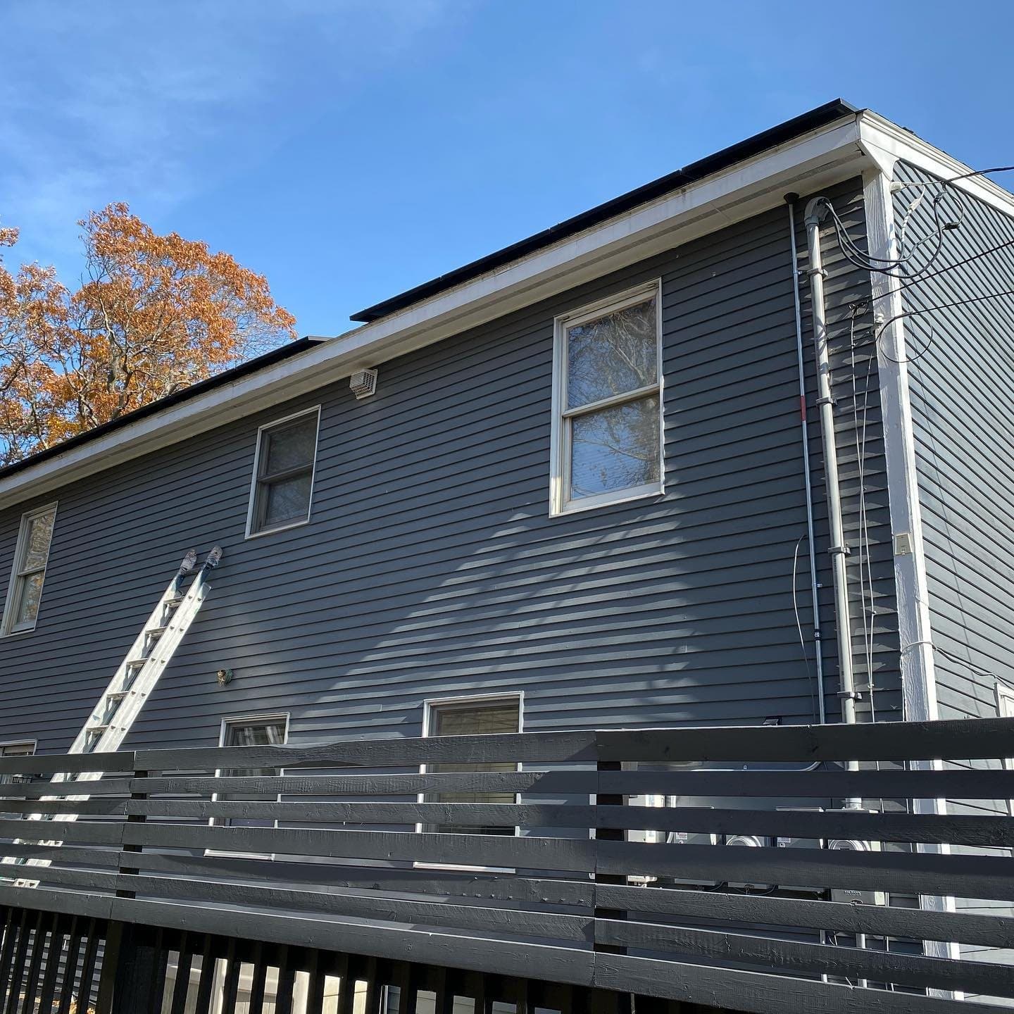 Grey siding with a horizontal slat fence