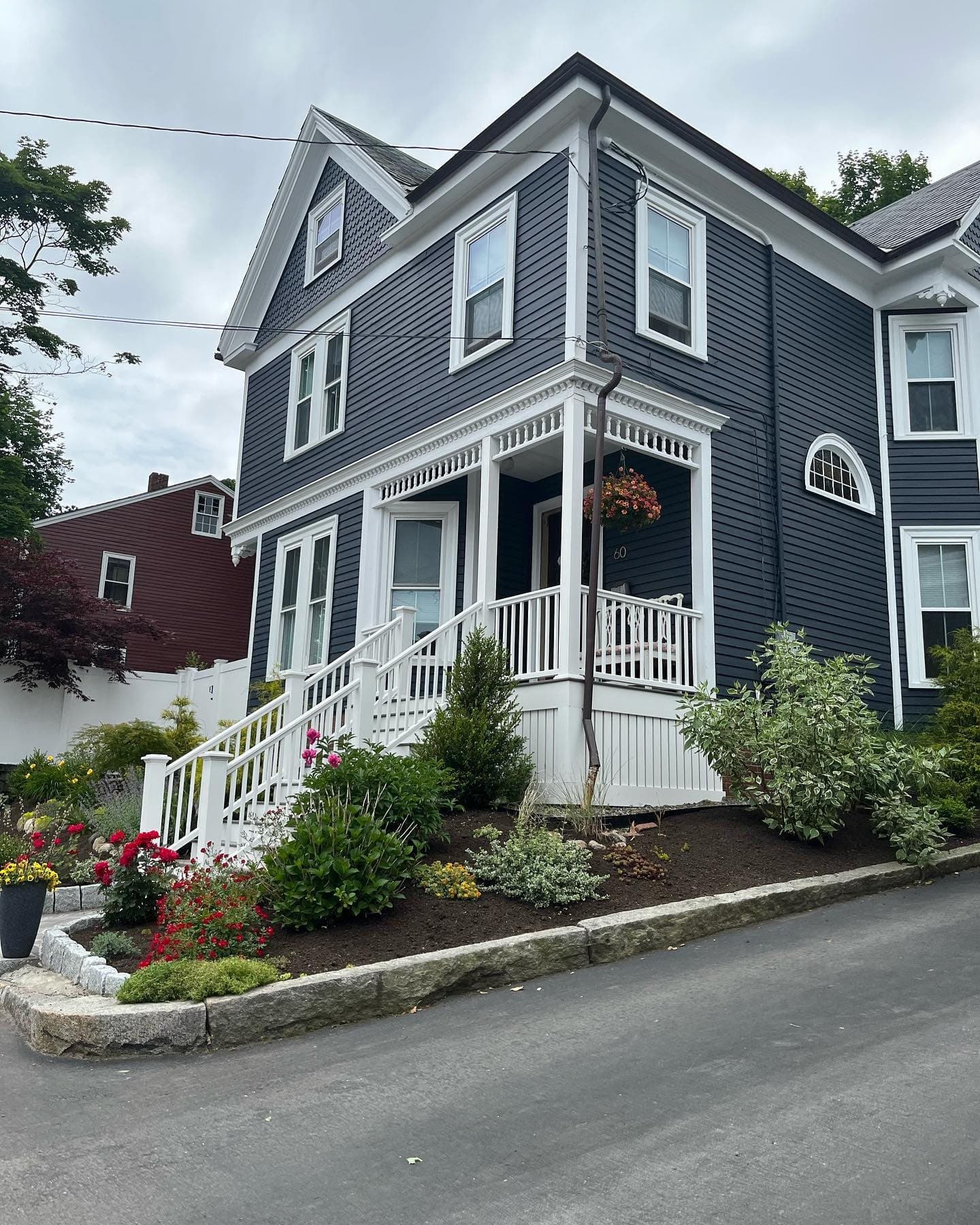 Navy Victorian home with a white front porch and new stairs