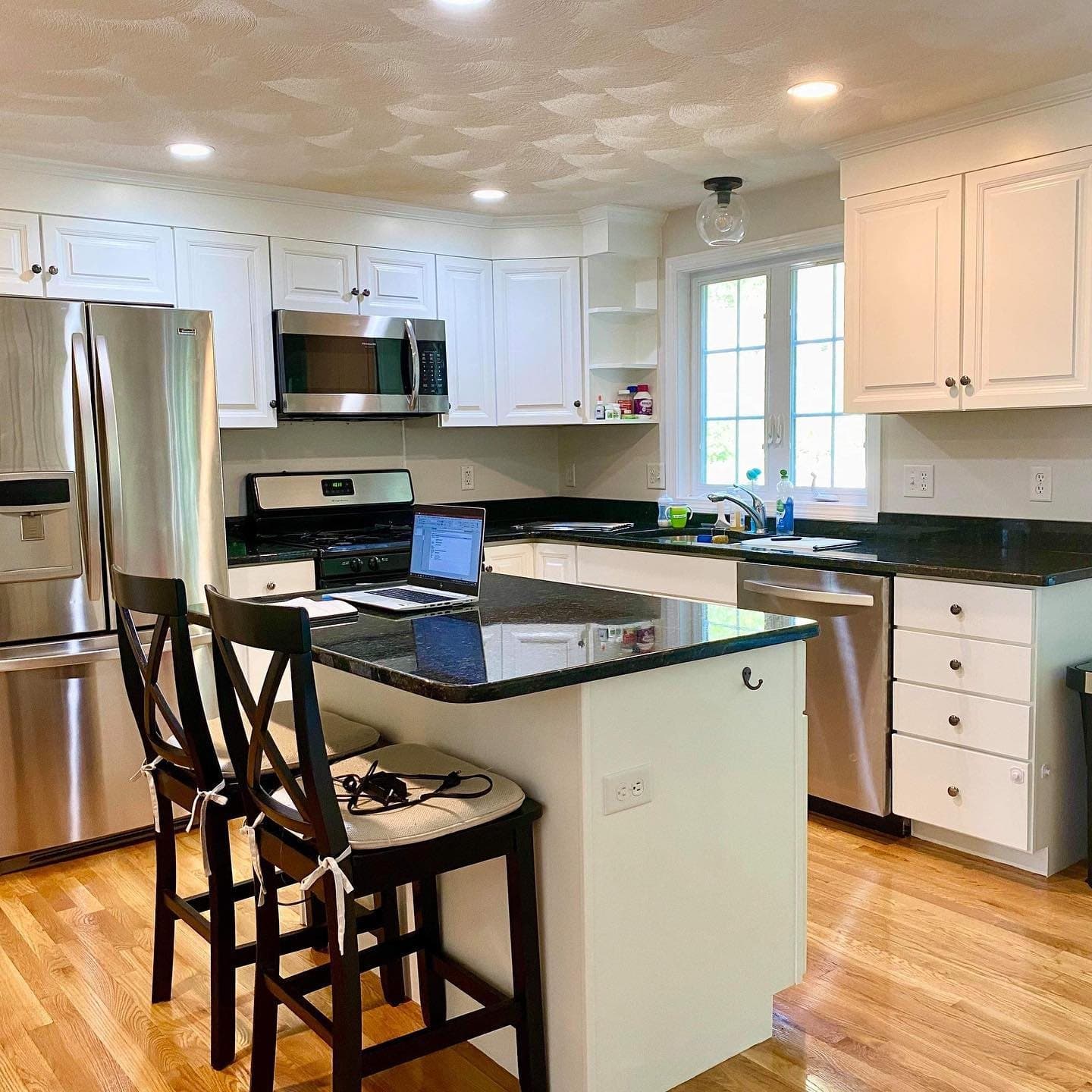 White kitchen with an island and stools